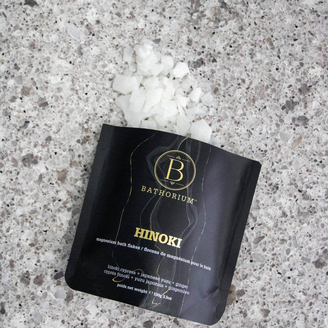 Bathorium Hinoki magnesium bath fakes packaging on a textured surface with white crystals.